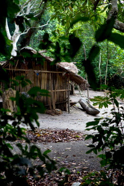 A dugout canoe lies beside a temporary hut built in a fishing village beside the Aruwimi River.