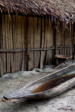 A dugout canoe, part-filled with rainwater, lies beside a temporary hut built in a fishing village beside the Aruwimi River.