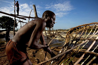 A Wagenia fisherman repairs his fish trap with  lianas that he will deploy in the Congo River