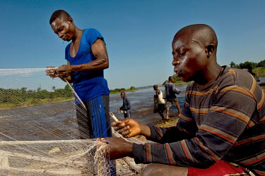 Wagenia fisherman repair their nets beside the Congo River.