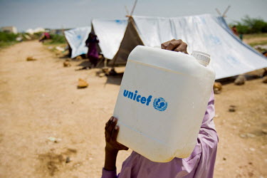 A man carries a container of clean water at a camp for people displaced by the floods that hit the country in July 2010.