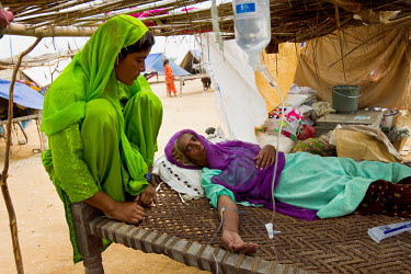 A woman lies on a bed, attached to a drip, following the floods that hit the country in July 2010.