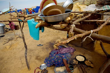 A woman cooks flat bread in the makeshift camp where she is living with her family following the floods that hit the country in July 2010.