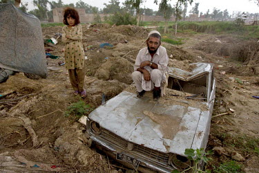 Nabi Jan,his daughter and the taxi car that was destroyed during the flooding that hit the country in July 2010, leaving the family without an income.