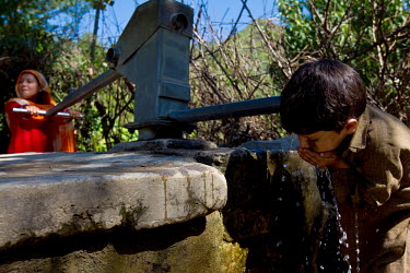 A girl pumps water while a boy drinks that hit the country in July 2010.