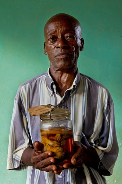 A worker at Yangambi research station with an ape (Old World Monkey, cercopithecidae) preserved in alcohol. During the era of Belgian colonial rule Yangambi was the largest tropical research centre in...
