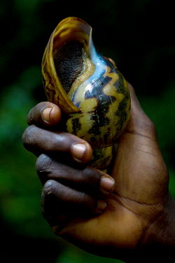 A man holds a large snail.