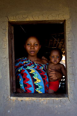 A woman and her child standing in the window of a building.