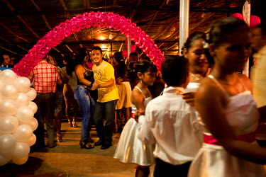 A couple dance at a qiunceanera (a girl's 15th birthday). It is often thought that a quinceanera is a way for a girl's parents to show possible suitors their girl is now a woman.