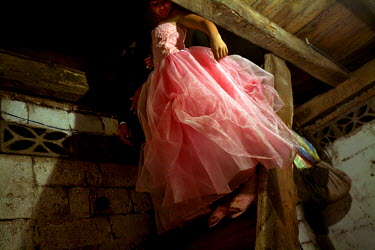 Yessina, a young girl about to turn 15, wearing a pink dress and slippers, which will later be replaced by high heels, at her qiunceanera (a girl's 15th birthday). It is often thought that a quinceane...