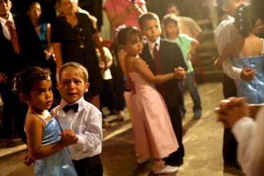 Young cousins dance in pairs at Yessina's qiunceanera (a girl's 15th birthday). It is often thought that a quinceanera is a way for a girl's parents to show possible suitors their girl is now a woman....