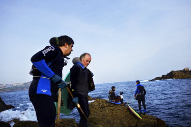Roberto Mahia (left) and Avelino Mosteiro (right) enter the ocean to harvest percebes (Goose barnacles) from the coastline of La Coruna. Percebes, considered a luxury seafood item, grow on the rocks o...
