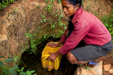 18 year old Rose Razanajaona struggles with a heavy jerry can on one of her many journeys to collect water. She says: 'There is a difference between girls and boys at my age, men are stronger than me...