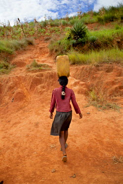 18 year old Rose Razanajaona struggles with a heavy jerry can on one of her many journeys to collect water. She says: 'There is a difference between girls and boys at my age, men are stronger than me...