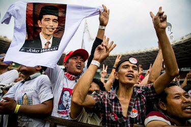 Supporters of Indonesian presidential candidate Joko Widodo cheer while he delivers his speech on the last day of the election campaign in Jakarta.