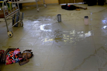 Mariattu Kanu, 4, (left) is suspected of being infected with Ebola. She is lying on the dirty floor of an isolation ward at the Makeni General Hospital where suspected Ebola patients are being kept. B...