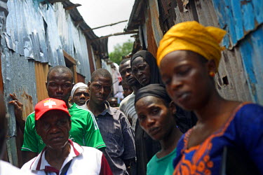 People gather in the street to listen to a group of volunteers speaking about the dangers of Ebola in a community in downtown Freetown , during the first day of the National lockdown.   The Sierra Leo...