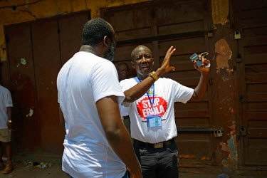 The newly appointed Minister of Health and Sanitation Dr. Abu Bakarr Sulaiman Fofanah (center) talks to a resident  during a house to house campaign.   The Sierra Leone government has declared a three...