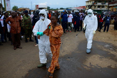 Emergency health workers take woman suspected of being infected with Ebola to the hospital. Emergency health services took hours to assist the woman and bring her to the hospital. The Sierra Leone gov...