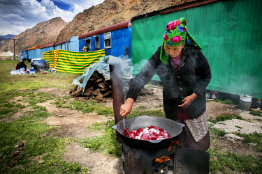 A woman makes raspberry jelly to sell to people travelling the Dolon Pass. During the summer months families move with their animals to a temporary camp in the mountains where they live in caravans an...