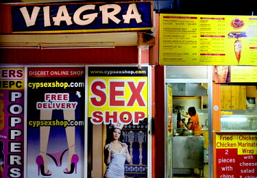 A closed down sex shop next to a 'Souvlaki' restaurant.