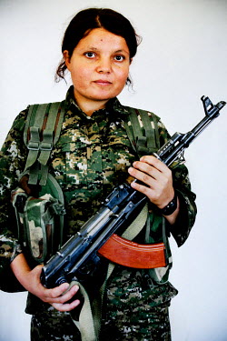 A 17 year old female soldier, from the YPJ (Women's Protection Unit), holding her Kalashnikov. The YPJ is a Kurdish female militia fighting the Islamic State and Jabhat al-Nusra in the primarily-Kurdi...