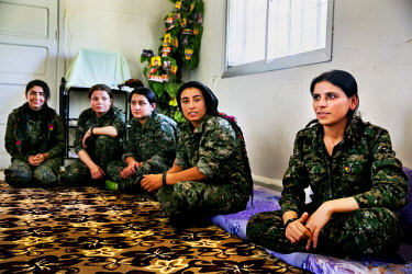Sozdar Amuda (34) sits with other female fighters in a carpeted room at their base. Sozdar is responsible for the YPJ's (Women's Protection Unit) base compound. She started her military career from th...