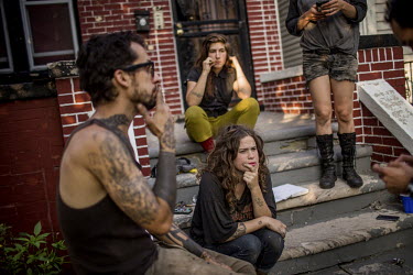 A group of young people sit on the steps outside a squatted house. Once the booming centre of the automobile industry the city is now bankrupt. Around the centre stretch mile after mile of vacant lots...