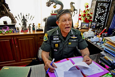 Police Major General Narasak Hemnithi, Commander of Natural Resource and Environment Crime Suppression Division (NRESCD) doing paperwork in his office.