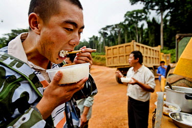 Chinese road builders take a meal break during the construction of a route between Libreville and Makokou.