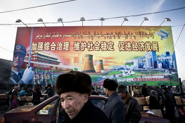 A billboard, hanging over a bread market, delivers a propaganda message from the Beijing authorities, encouraging good relations between Han and Uyghurs. The percentage of ethnic Han Chinese in Xinjia...