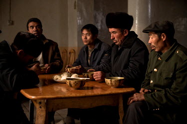 Uyghur men eating mutton dumplings and soup at a roadside restaurant.