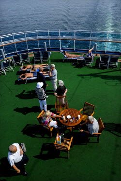 Tourists on board a luxury cruise liner. These vast ships carry thousands of passengers and thousands more staff to cater for their every need.