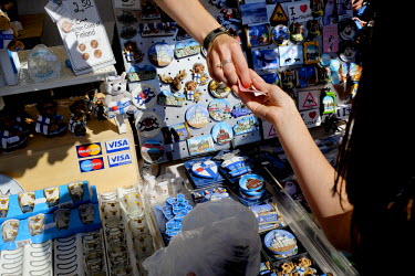 A stall holder passes change to a customer at a stand in the Mina Market selling tourist souvenirs.