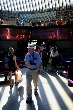 An American tourist visits Helsinki's Temppeliaukio Church. The church was built in the 1960's, carved from the bedrock to replace a church that was previously damaged during the Second World War. The...