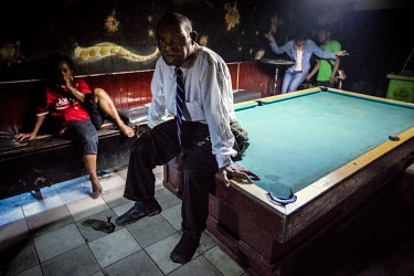 A security guard sits on a billiard table in one of the night clubs of Port Moresby. Most of the cases of violence against women happen on a weekend, when much of the male population of Papua New Guin...