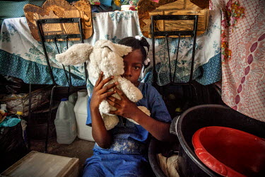 Mamose (12), a 'restavek' plays with her sole toy, a fluffy bunny, while her master is out. 'Restaveks' are children whose impoverished parents have indentured them into domestic labour in the hope th...