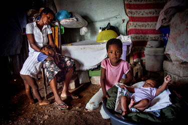 Amberline (7, right) with her three-month-old brother, Loubes. Their mother Adeline (32, left) cannot afford to feed her three children or pay for Amberline’s schooling. Adeline says that in a few m...