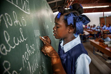 A 12 year old 'restavek' learning to count at the Kwadbouke School. 'Restaveks' are children whose impoverished parents have indentured them into domestic labour in the hope that the child will get fo...