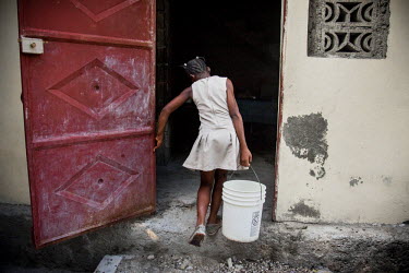 Judeline, a 'restavek' carries a heavy bucket of water from the well to her 'master's' house. She goes to school, but can only do her homework once she has finished all if the household chores. She is...