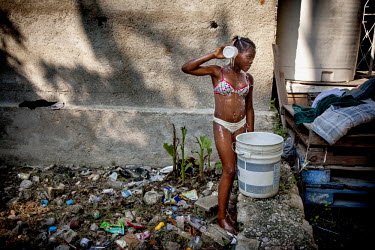 Judeline (12), a 'restavek', has a bucket wash in the yard behind the house. She is not allowed to use the bathroom inside. 'Restaveks' are children whose impoverished parents have indentured them int...