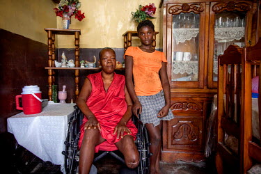 Jeanse (16), a 'restavek' stands near her 'master' Jean-Felix Lousienne (44), who took her from the Petion-Ville refugee camp. Jeanse sleeps and eats on the floor and is constantly exposed to beatings...