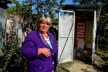 Pana Dumitra, 49, beside her outside toilet. She lives, as almost half of the Romanian population do, in the countryside. The municipality there provides no running water or sewage. People have wells...