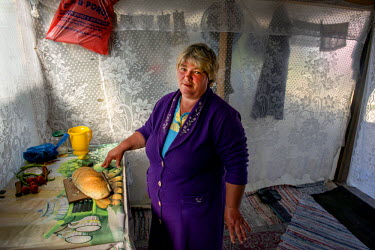 Pana Dumitra, 49, in her kitchen. She lives, as almost half of the Romanian population do, in the countryside. The municipality there provides no running water or sewage. People have wells from which...