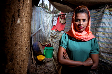 Meseret stands beside the toilet facilities at her home in Addis Ababa. Her husband was shot during the aftermath of the 2005 elections. Since she has been a widow for nine years now she is tries to l...
