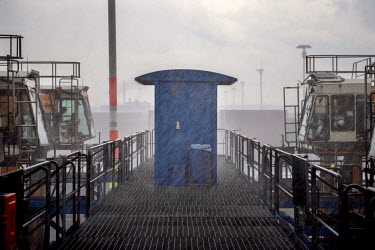 The straddle carrier station during a storm. Straddle carriers are very high vehicles that carry the containers to the ship ready for loading.