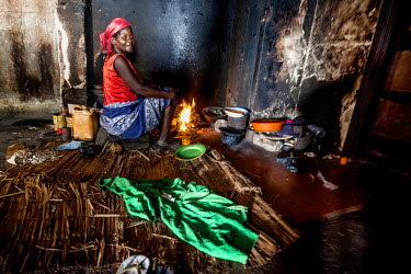A woman cooks food on an open fire inside the former Grand Hotel building. Once a luxury destination for the wealthy and the continent's biggest hotel, the building is now a concrete shell and home to...