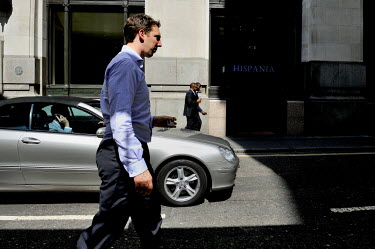 A man, illegally, using a mobile phone whil edriving along Lombard Street in the CIty of London.
