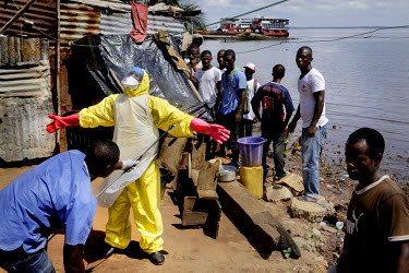 An IFRC Safe and Dignified Burial Team disinfecting themselves before taking off the PPE (personal protection equipment) after collecting the body of fisherman Mohammed Kamara, 52, from the Ferry Term...