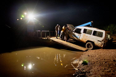 A UNHCR/IEDA team's vehicle breaks down while off-loading from a night ferry crossing of the Congo River during a trip researching human rights violations at Kasonsa village. The journey to Kasonsa wa...